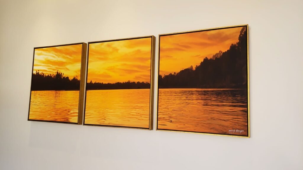 Díptico de pôr do sol sobre a água, de Marcelo Menezes, instalado em parede clara